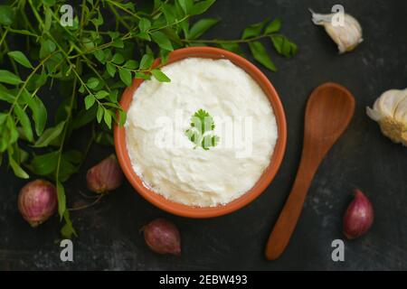 Bol de crème aigre maison yaourt Dahi herbes fraîches curry feuille Kerala, Inde. Femme prendre à la main produit laitier obtenu coagulant lait caillé Banque D'Images