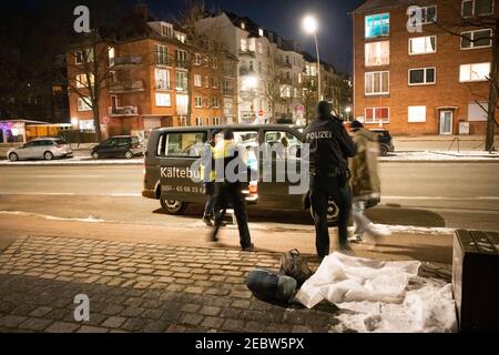 Hambourg, Allemagne. 12 février 2021. Deux agents de police accompagnent une personne sans domicile jusqu'au bus froid. Le bus froid de Hambourg existe depuis janvier 2019. Il se rend aux sans-abri qui ont besoin d'aide dans la rue et peuvent les emmener à l'abri. Les citoyens ont l'occasion d'attirer l'attention sur les sans-abri qui pourraient être à risque. Credit: Christian Charisius/dpa/Alay Live News Banque D'Images