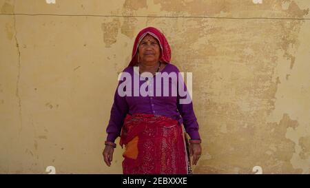 08 février 2021 - Khatoo, Jaipur, Inde. Belle vieille femme indienne avec une tenue traditionnelle. Homme donnant un sourire joyeux avec un fond jaune. Banque D'Images