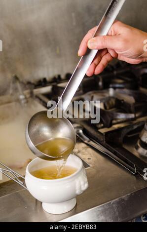 Servir le bouillon dans des pâtes farcies marubini bown dans un professionnel cuisine Banque D'Images