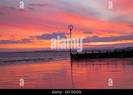 Portobello, Édimbourg, Écosse, météo britannique. 13 février 2021. Ciel rouge et coloré pour le début du week-end de la Saint-Valentin au lever du soleil sur Firth of Forth. Banque D'Images