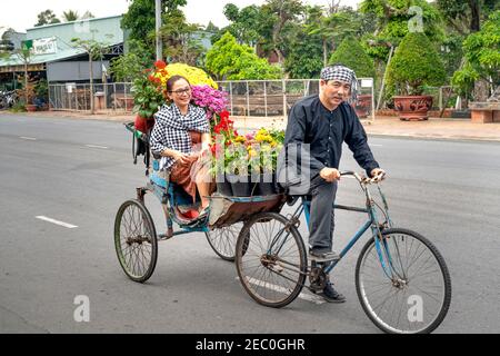 Sa Dec Town, province de Dong Thap, Vietnam - 7 février 2021 : un homme conduit un tricycle transportant des fleurs pendant le nouvel an lunaire à sa Dec Town, Dong T. Banque D'Images