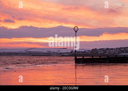 Portobello, Édimbourg, Écosse, météo britannique. 13 février 2021. Ciel rouge et coloré pour le début du week-end de la Saint-Valentin au lever du soleil au-dessus de Firth of Forth. Banque D'Images