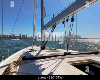 Yacht naviguant vers la ville dans le port de Sydney, par une journée ensoleillée. Vue depuis le cockpit du bateau jusqu'à la ville Banque D'Images