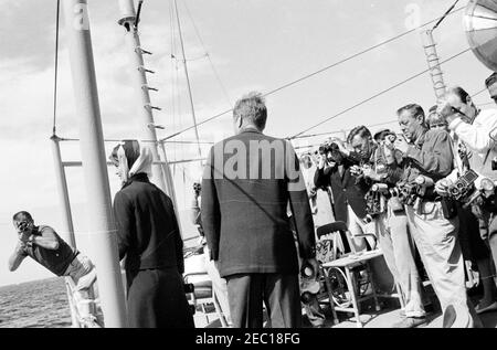 Le Président Kennedy Watches la 1ère course de la coupe Americau0027s. Le président John F. Kennedy (au centre) et la première dame Jacqueline Kennedy (à gauche) regardent la première course de la coupe Americau0027s 1962 à bord de l'USS Joseph P. Kennedy, Jr. Également en photo: Hugh D. Auchincloss; sous-secrétaire de la Marine, Paul u0022Redu0022 Fay. Des photographes non identifiés observent. Newport, Rhode Island. Banque D'Images