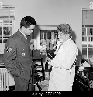 Homme avec un singe de recherche lors d'une fête d'anniversaire à la Maison Blanche. Un sergent d'état-major de la Force aérienne non identifié et un homme non identifié avec un singe de recherche dans une pièce non identifiée de l'aile est, deuxième étage, Maison Blanche, Washington, D.C. Banque D'Images