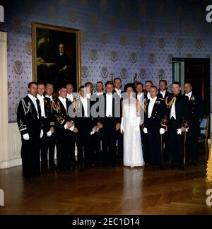 Président Kennedy u0026 première Dame Jacqueline Kennedy (JBK) avec des assistants sociaux de la Maison Blanche, vers 7 h 50. Le président John F. Kennedy et la première dame Jacqueline Kennedy se tiennent aux côtés des assistants sociaux de la Maison Blanche avant un dîner en l'honneur du président de la Côte d'Ivoire, Fu00e9lix Houphouu00ebt-Boigny; le lieutenant de marine des États-Unis, Ronald Scott Purvis, est à l'extrême droite. Tous les autres assistants sociaux ne sont pas identifiés. Blue Room, Maison Blanche, Washington, D.C. Banque D'Images