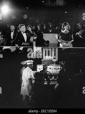 Deuxième Salute inaugurale au dîner du Président, 7:30. Le président John F. Kennedy (à gauche) et la première dame Jacqueline Kennedy (à droite) sont assis dans la boîte présidentielle lors de la deuxième salutation inaugurale au président alors que plusieurs chefs (ci-dessous) portent un gâteau commémorant le deuxième anniversaire de l'investiture du président Kennedyu0027s. Sont également photographiés, assis avec les invités d'honneur, Bedford S. Wynne, président de l'événement; la princesse Lee Radziwill, de Pologne, la première sœur de Ladyu0027s; le sénateur Hubert H. Humphrey (Minnesota); le représentant Carl Albert (Oklahoma); et le président du démocrate Banque D'Images