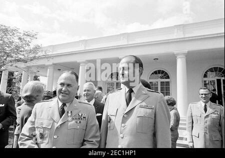 Remise de la Médaille du service distingué au général George H. Decker, 12 h 05. Le général George H. Decker (à gauche), chef d'état-major sortant de l'armée des États-Unis, visite le général Earle G. Wheeler, chef d'état-major de l'armée des États-Unis, après avoir reçu la Médaille du service distingué (DSM); le général J. Lawton Collins (au centre à gauche) est en arrière-plan. Rose Garden, Maison Blanche, Washington, D.C. Banque D'Images