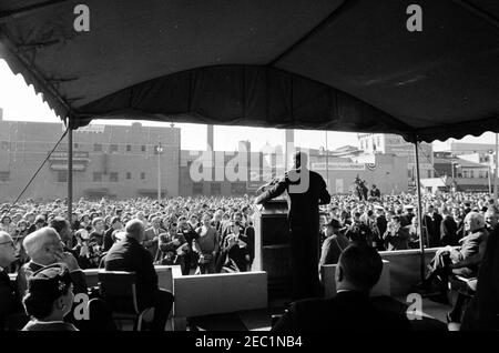 Voyage de campagne du Congrès : McKeesport, Pennsylvanie, rallye. Le président John F. Kennedy (au lectern) prononce un discours à l'occasion d'un rassemblement de campagne du Congrès dans le parc de stationnement municipal de l'hôtel de ville de McKeesport, en Pennsylvanie. Assis sur la plate-forme : le maire de McKeesport, Andrew Jakomas; le gouverneur de Pennsylvanie, David L. Lawrence; le candidat pour le gouverneur de Pennsylvanie et ancien maire de Philadelphie, Richardson Dilworth. Banque D'Images