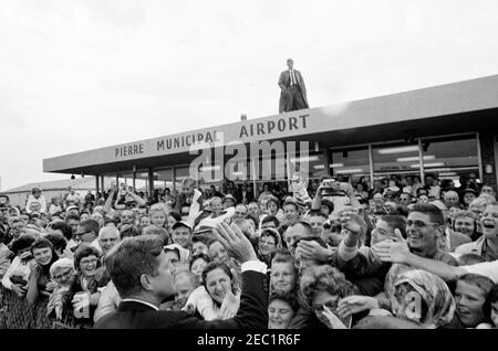 Voyage aux États de l'Ouest : Pierre, Dakota du Sud (barrage d'Oahe), 10:25. Le président John F. Kennedy se déferle devant de la foule à son arrivée à l'aéroport municipal de Pierre à Pierre, Dakota du Sud; le président Kennedy s'est rendu au Dakota du Sud pour assister à l'inauguration du barrage et du réservoir d'Oahe. Banque D'Images