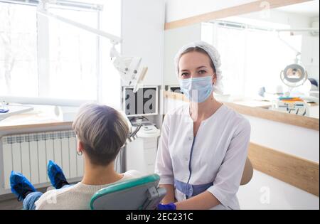 Portrait de dentiste féminin. Elle se tenant et souriant avec les bras croisés dans son cabinet de dentiste Banque D'Images