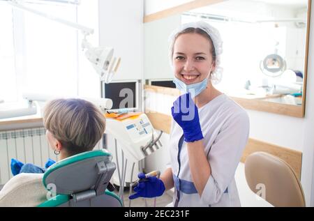 Portrait de dentiste féminin. Elle se tenant et souriant avec les bras croisés dans son cabinet de dentiste Banque D'Images