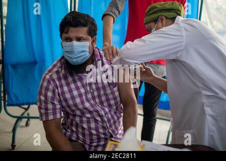 Une infirmière vaccine une femme avec le vaccin Covid 19 dans un hôpital de Dhaka, au Bangladesh Banque D'Images
