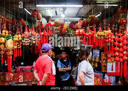 Ongpin St., Binondo, Manille, Philippines. 13 février 2021. Les gens regardant les charmes chanceux à acheter à Ongpin St., Binondo, pendant le nouvel an chinois. Binondo est connu comme le plus vieux quartier chinois du monde, la majorité des célébrations comme les danses de dragon et de lion ont été annulées en raison de la pandémie. Crédit : CIC de la majorité mondiale/Alamy Live News Banque D'Images