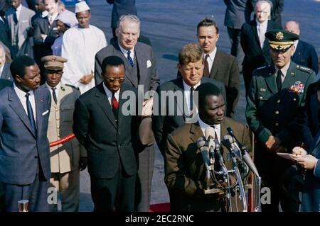 Cérémonie d'arrivée pour Ahmed Su00e9kou Touru00e9, Président de la Guinée, 11 h 00. Le Président de la Guinée, Ahmed Su00e9kou Touru00e9, prononce des remarques lors des cérémonies d'arrivée en son honneur. Permanent sur la plate-forme d'examen en avant-plan (L-R) : le ministre des Affaires étrangères de Guinée, Louis Lansana Bu00e9avogui; l'ambassadeur de Guinée, Dr. Seydou Conte; le sous-secrétaire d'État américain, George ball; le président Touru00e9 (à micros); le président John F. Kennedy; l'ambassadeur des États-Unis en Guinée, William Attwood (à l'arrière-plan); Président des chefs d'état-major interarmées, le général Maxwell D. Taylor. Également illustré (à Banque D'Images