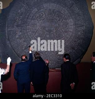 Voyage au Mexique : visite de l'Institut national d'anthropologie et d'histoire, 4:55. Le Président John F. Kennedy voit la Piedra del sol (calendrier aztèque, pierre du Soleil) lors d'une visite du Museo Nacional de Antropologu00eda (Musée national d'anthropologie) de l'Instituto Nacional de Antropologu00eda e Historia (Institut national d'anthropologie et d'histoire) à Mexico, Mexique. De gauche à droite : Chef du Département culturel de l'Instituto Nacional de Antropologu00eda e Historia, Joaquu00edn Cortina Goribar; Président Kennedy; non identifié (pour la plupart caché); Directeur de l'Instituto NAC Banque D'Images