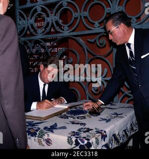 Voyage au Mexique : visite de l'Institut national d'anthropologie et d'histoire, 4:55. Le Président John F. Kennedy signe le livre d'or lors d'une visite du Museo Nacional de Antropologu00eda (Musée national d'anthropologie) de l'Instituto Nacional de Antropologu00eda e Historia (Institut national d'anthropologie et d'histoire) à Mexico, au Mexique. Directeur de l'Instituto Nacional de Antropologu00eda e Historia, Dr. Eusebio Du00e1valos Hurtado (à gauche), et directeur du Museo Nacional de Antropologu00eda, Arturo Romano Pacheco (à droite), observez. Banque D'Images