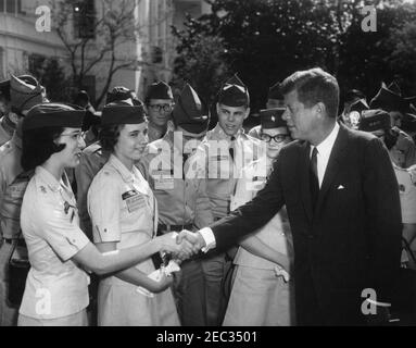 Visite des cadets de la patrouille aérienne civile, 9 h 50. Le président John F. Kennedy (à droite) visite un groupe de cadets de la patrouille aérienne civile dans le jardin des roses de la Maison Blanche, Washington, D.C., de gauche à droite : Cadet 1er Lieutenant Patricia Jean Lewis de Virginie-Occidentale (entre la main avec le Président), cadet 2e Lieutenant Lynn Ann Brusina du Nouveau-Mexique, cadet 2e Lieutenant Ronald Lang de Pennsylvanie, capitaine de cadet James David Tegeder du Minnesota, cadet Major Julianne G. Glowacki du Massachusetts, et président Kennedy. Banque D'Images