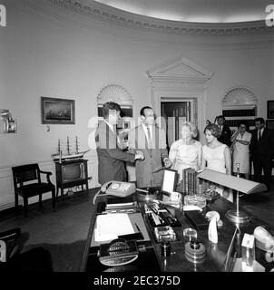 Visite de Stan Musial, joueur de la Ligue majeure de baseball (MLB) pour les Cardinals de Saint-Louis, et de la famille, 4:10. Le président John F. Kennedy tremble la main avec Stan Musial, joueur de la Ligue majeure de baseball (MLB) pour les Cardinals de Saint-Louis lors d'une visite dans le Bureau ovale. Sa femme, Lillian Musial, et sa fille, Janet Musial, regardent de droite. En arrière-plan (G-D): Agent du service secret de la Maison Blanche, Charlie Kunkel; correspondant de la Maison Blanche pour United Press International (UPI), Helen Thomas; non identifié. White House, Washington, D.C. Banque D'Images