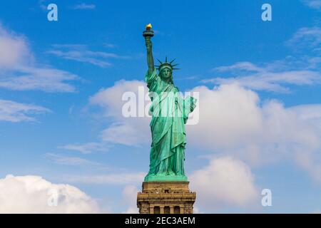 Vue de face de la Statue de la liberté sur fond bleu ciel en arrière sur une journée ensoleillée et nuageux Banque D'Images