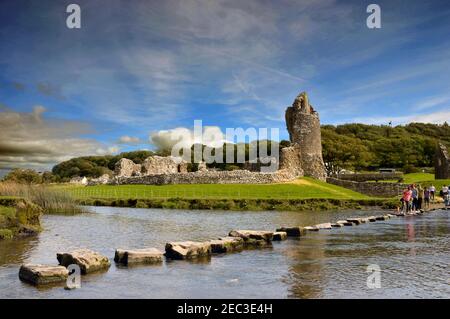 Ogmore, pays de Galles - août 2017 : pierres sur la rivière Ogmore avec les ruines du château du XIIe siècle en arrière-plan Banque D'Images