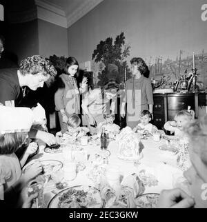 Fête d'anniversaire pour Caroline Kennedy et John F. Kennedy, Jr. John F. Kennedy, Jr. (Assis au centre), mange à une table dans la salle à manger du Presidentu2019s (résidence) de la Maison Blanche, Washington, D.C., lors d'une fête d'anniversaire conjointe pour lui et sa sœur, Caroline Kennedy; la première dame Jacqueline Kennedy se tient derrière son fils. Banque D'Images