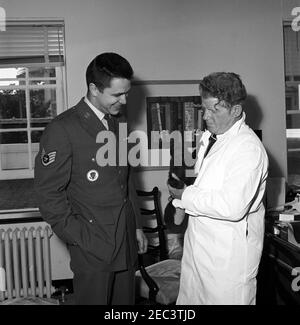 Homme avec un singe de recherche lors d'une fête d'anniversaire à la Maison Blanche. Un sergent d'état-major de la Force aérienne non identifié et un homme non identifié avec un singe de recherche dans une pièce non identifiée de l'aile est, deuxième étage, Maison Blanche, Washington, D.C. Banque D'Images