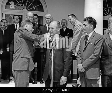 Présentation des Prix du service civil distingué, 11 h 30. Le président John F. Kennedy remet le Prix du Presidentu0027s pour service civil fédéral distingué au directeur du Service de la circulation aérienne de l'Agence fédérale de l'aviation (FAA), David D. Thomas (au centre, derrière les microphones), lors d'une cérémonie dans le jardin des roses de la Maison Blanche, Washington, D.C. Administrateur de la FAA, Najeeb Halaby, Et le président du Conseil des prix civils distingués et sous-secrétaire d'État, George ball (pour la plupart caché sur le bord du cadre), observent à droite. Debout en arrière-plan (de gauche à droite): Moi Banque D'Images