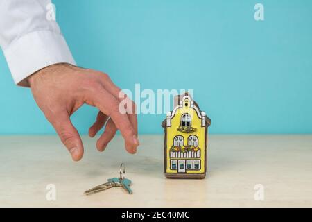 Modèle de maison et clé en main, concept immobilier, espace copie couleur turquoise. Banque D'Images