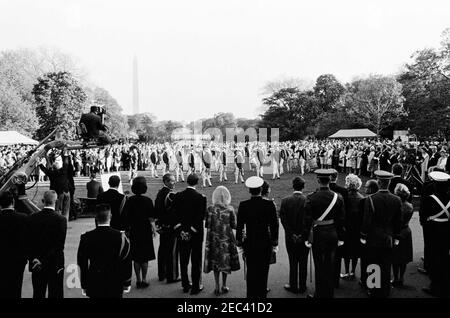 Le Président Kennedy salue les récipiendaires de la Médaille d'honneur du Congrès, réception militaire annuelle, 6 h 03. Vue de la pelouse sud de la Maison Blanche, comme le président John F. Kennedy (à l'extrême droite, de retour à la caméra) et d'autres regardent l'Old Guard Fife and Drum corps, 1er Bataillon, 3e Régiment d'infanterie, se produire lors d'une réception militaire en l'honneur des récipiendaires de la Médaille d'honneur du Congrès. Les photos incluent : l'aide navale au président, le capitaine Tazewell Shepard; Julia Ann Shepard, épouse du capitaine Shepard; l'aide militaire au président, le général Chester V. Clifton; le procureur général Robert Banque D'Images