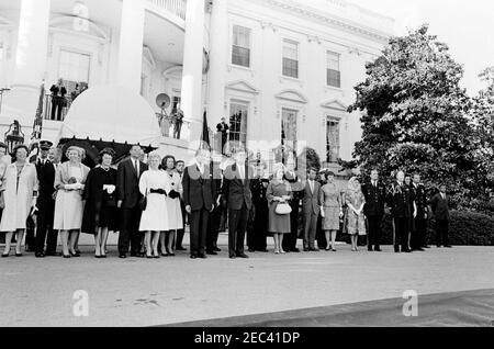 Le Président Kennedy salue les récipiendaires de la Médaille d'honneur du Congrès, réception militaire annuelle, 6 h 03. Le Président John F. Kennedy et d'autres assistent à une réception militaire en l'honneur des récipiendaires de la Médaille d'honneur du Congrès. De gauche à droite : plusieurs personnes non identifiées; Margaret McNamara (manteau noir), épouse de Robert S. McNamara, secrétaire à la Défense; Secrétaire McNamara; Secrétaire de la Marine, Fred Korth (derrière McNamara); Madelin T. Gilpatric, épouse de Roswell L. Gilpatric, secrétaire adjoint à la Défense; Phyllis Chess Ellsworth, épouse de C. Douglas Dillon, secrétaire au Trésor; Banque D'Images