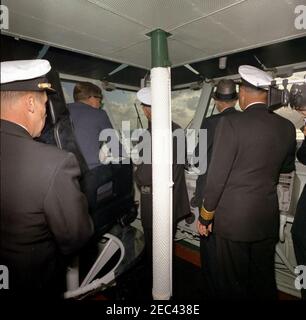 Voyage aux États de l'Ouest : visite de la flotte du Pacifique, le président Kennedy à bord de l'USS Kitty Hawk, 5:00. Le président John F. Kennedy (portant des lunettes de soleil) est assis dans le fauteuil du captainu0027s, dans le pont du porte-avions USS Kitty Hawk (CVA-63), au large de la côte de San Diego. Également en photo : le secrétaire de la Marine, Fred Korth; le commandant de la division Carrier 1, le contre-amiral Paul Masterton. Banque D'Images