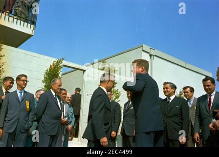 Voyage aux États de l'Ouest : Los Angeles, Californie, arrivée à l'hôtel Beverly Hilton pour un dîner de collecte de fonds, 3:40. Le président John F. Kennedy (à droite) accueille un groupe de personnes non identifiées, après son arrivée à l'héliport sur le toit de l'hôtel Beverly Hilton à Los Angeles, en Californie. Les photos sont les suivantes : vice-président des hôtels Hilton, Barron Hilton (à l'extrême droite) ; photographe de la Maison Blanche, chef Robert L. Knudsen (près de la porte au centre à gauche) ; agent du service secret de la Maison Blanche, Emory Roberts (à l'extrême gauche). Le président Kennedy s'est rendu à Los Angeles pour assister à un dîner de collecte de fonds du Parti démocratique Banque D'Images