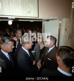 Voyage dans les États de l'Ouest : Los Angeles, Californie, Beverly Hilton Hotel, President Kennedy et Jack Benny visitez le bal senior de l'école secondaire John Burroughs, 10:22. Le président John F. Kennedy (en bas à gauche) se serre la main avec un homme non identifié, lors d'une visite à la promenade principale de l'école secondaire John Burroughs de Burbank, Californie, dans la grande salle de bal de l'hôtel Beverly Hilton, Los Angeles, Californie. Le président Kennedy et le comédien Jack Benny (debout derrière le président, portant des lunettes) ont visité la danse après avoir assisté à un dîner de collecte de fonds dans le même hôtel ; également en photo : Maison Blanche Banque D'Images