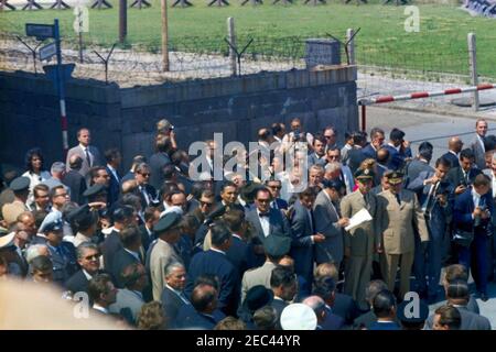 Voyage en Europe: Allemagne, Berlin-Ouest: Président Kennedy à Checkpoint Charlie, 12:05. Le président John F. Kennedy (au centre à gauche en premier plan, de retour à la caméra) visite le mur de Berlin près de Checkpoint Charlie à Berlin-Ouest, Allemagne de l'Ouest (République fédérale). Également en photo : le chancelier de l'Allemagne de l'Ouest, Konrad Adenauer; le maire de Berlin Ouest, Willy Brandt; le chef du protocole des États-Unis, Angier Biddle Duke; le secrétaire d'État des États-Unis, Dean Rusk; Jay W. Gildner, de l'Agence d'information des États-Unis (USIA); Les agents du service secret de la Maison Blanche, James J. Rowley, Gerald A. u201cJerryu201d Behn et Roy Kellerman. Banque D'Images