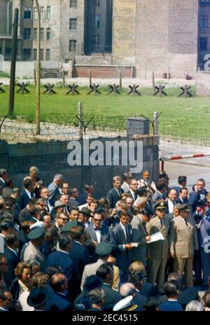 Voyage en Europe: Allemagne, Berlin-Ouest: Président Kennedy à Checkpoint Charlie, 12:05. Le président John F. Kennedy (au centre à gauche en premier plan, de retour à la caméra) visite le mur de Berlin près de Checkpoint Charlie à Berlin-Ouest, Allemagne de l'Ouest (République fédérale). Également en photo : le chancelier de l'Allemagne de l'Ouest, Konrad Adenauer; le maire de Berlin Ouest, Willy Brandt; Eunice Kennedy Shriver; le chef du protocole des États-Unis, Angier Biddle Duke; le secrétaire d'État des États-Unis, Dean Rusk; Jay W. Gildner, de l'Agence d'information des États-Unis (USIA); Gerald A. u201cJerryu201d Behn. Banque D'Images