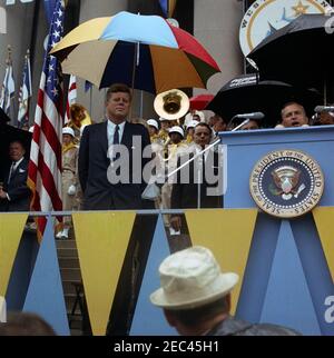 Voyage en Virginie occidentale : discours à l'occasion de la célébration du centenaire de la Virginie occidentale, bâtiment du Capitole de l'État, Charleston, 11:30. Le Président John F. Kennedy (à gauche) assiste à une célébration commémorant le centenaire de la Virginie-Occidentale sur les marches du Capitole de l'État à Charleston, en Virginie-Occidentale. Le gouverneur de la Virginie-Occidentale, William W. Barron, parle de derrière le lutrin à droite. Également en photo : des sénateurs de Virginie-Occidentale, Robert C. Byrd (à droite du président Kennedy) et Jennings Randolph (la plupart du temps cachés derrière le lutrin); Ron Pontius, agent du Service secret de la Maison Blanche. [Photo de Harold Sellers] Banque D'Images