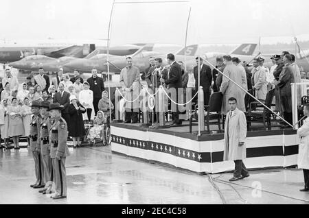 Croisière le week-end dans le Maine : arrivée à la base aérienne navale (NAS) Brunswick, Maine, 6:15PMrnrn. Cérémonie d'arrivée en l'honneur du président John F. Kennedy à la base aérienne navale de Brunswick, Maine; le sénateur Edmund S. Muskie (Maine) prononce un discours. Également en photo : le procureur, William D. Hathaway; l'administrateur adjoint de l'Agence pour le développement international (AID), Frank M. Coffin (partiellement caché); le sénateur Benjamin A. Smith, II (Massachusetts); le gouverneur du Maine, John H. Reed; l'agent du service secret de la Maison Blanche, Ken Giannoules. Des jets de l'escadron des Blue Angels Navyu2019s des États-Unis sont assis Banque D'Images