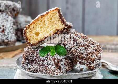 Lamington Cake Squares - gâteaux éponge australiens traditionnels recouverts de sauce au chocolat et noix de coco déshydratée Banque D'Images