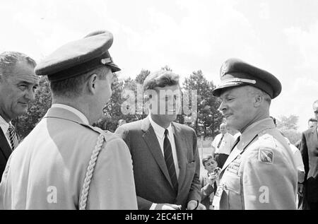 Visite d'inspection des installations de la NASA : Huntsville Alabama, Redstone Army Airfield et George C. Marshall Space Flight Centre, 9:35. Le président John F. Kennedy s'entretient avec un officier non identifié du US Army missile Command (à droite), lors d'une visite au George C. Marshall Space Flight Centre (MSFC) à Redstone Arsenal, Huntsville, Alabama; Le vice-président Lyndon B. Johnson et l'aide militaire au président, le général Chester V. Clifton (de retour à la caméra), sont à gauche. Le président Kennedy a visité la MSFC dans le cadre d'une visite d'inspection de deux jours de la National Aeronautics and Space Administration (N Banque D'Images