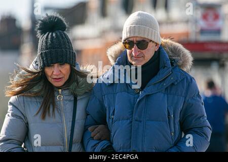 PUTNEY LONDON, ROYAUME-UNI, 13 FÉVRIER 2021. Les piétons se enveloppent dans des foulards et des vêtements d'hiver lors d'une matinée éclatante et croustillante le jour du pont Putney alors que les températures chutent en dessous de zéro. Credit amer ghazzal/Alamy Live News Banque D'Images