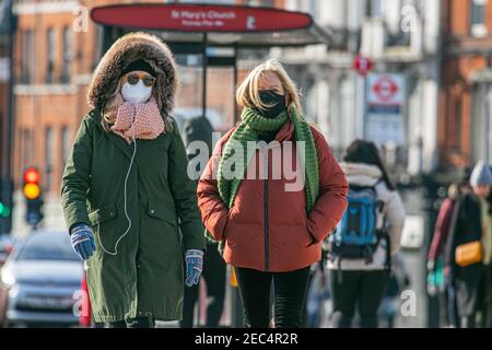 PUTNEY LONDON, ROYAUME-UNI, 13 FÉVRIER 2021. Les piétons se enveloppent dans des foulards et des vêtements d'hiver lors d'une matinée éclatante et croustillante le jour du pont Putney alors que les températures chutent en dessous de zéro. Credit amer ghazzal/Alamy Live News Banque D'Images