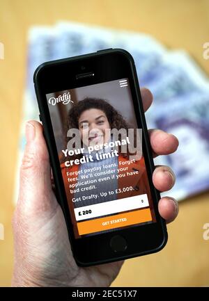 Une femme utilisant le site Web de drawty à la recherche d'un prêt sur son téléphone portable Banque D'Images