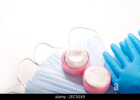 Accessoires de beauté sur fond blanc. Gants bleus, masques et crème. Banque D'Images