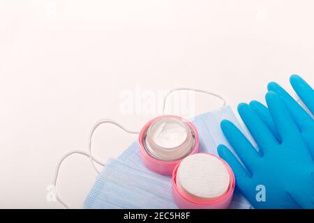 Accessoires de beauté sur fond blanc. Gants bleus, masques et crème. Banque D'Images