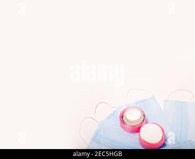 Accessoires de beauté sur fond blanc. Gants bleus, masques et crème. Banque D'Images