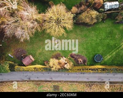 Vue sur un jardin à l'arrière d'une maison de campagne anglaise, montrant des enfants jouant au football par une journée ensoleillée. Banque D'Images