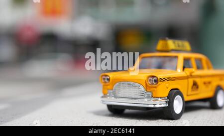 Jaune cabine de mini taxi vacante à proximité, Harmon Corner, Las Vegas, Etats-Unis. Petit modèle de voiture rétro sur fond flou. Petit jouet automobile emblématique comme symbole o Banque D'Images