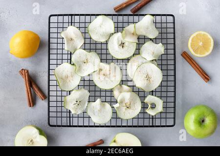 composition de la couche plate avec des chips de pomme déshydratées, des pommes, des citrons et des bâtons de cannelle Banque D'Images